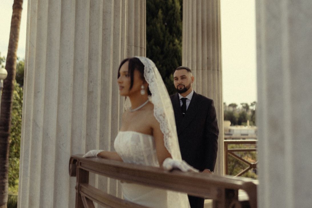 Photo d'un couple où l'homme regarde la femme et la femme regarde l'objectif, les cheveux au vent